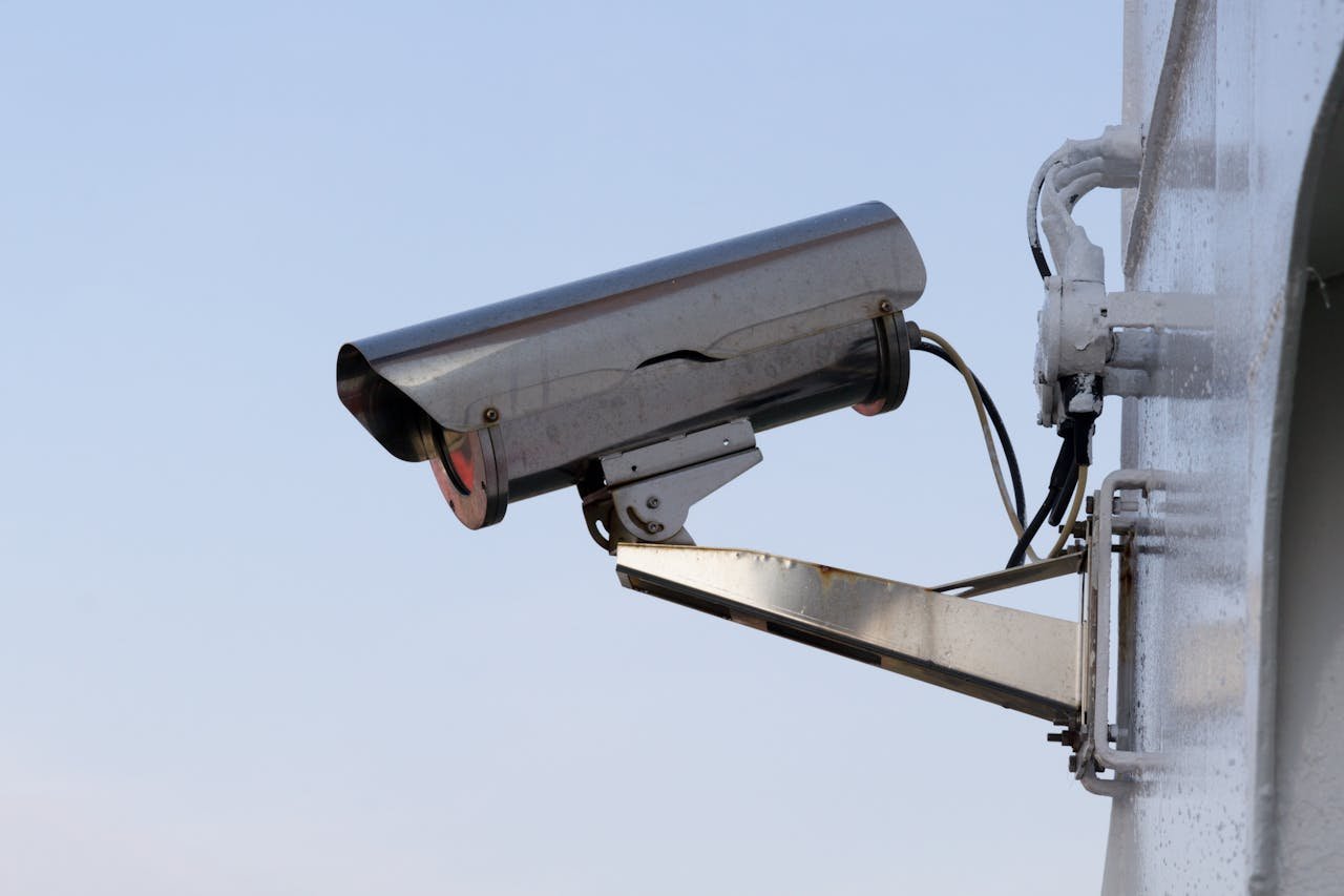 get-in-touch Close-up of an outdoor CCTV camera installed on a wall for security purposes.